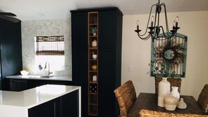 A modern kitchen with a central island, a dining area with wicker chairs, and a decorative wall piece. - Put some MAGIC into your vacation.  Disney only 20 minutes away! (Haines City)