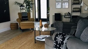 A living room with a sofa, armchair, coffee table, and a large window. - Put some MAGIC into your vacation.  Disney only 20 minutes away! (Haines City)