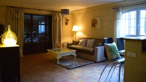 A living room with a sofa, a coffee table, a lamp, and a chair. - An independent apartment in a pretty property in the countryside ... (CORNILLON CONFOUX)