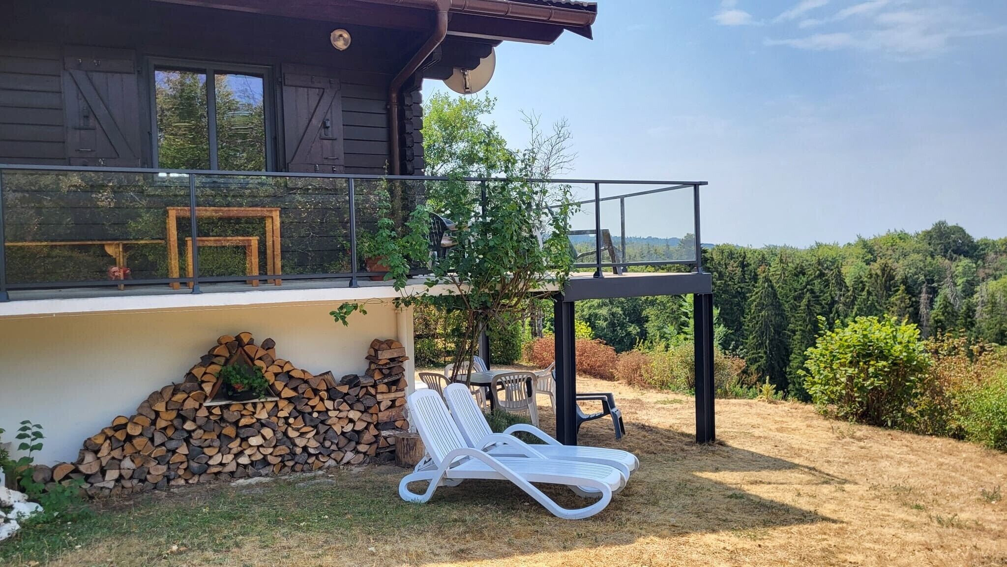 Une maison moderne dotée d’un balcon donnant sur une zone boisée.