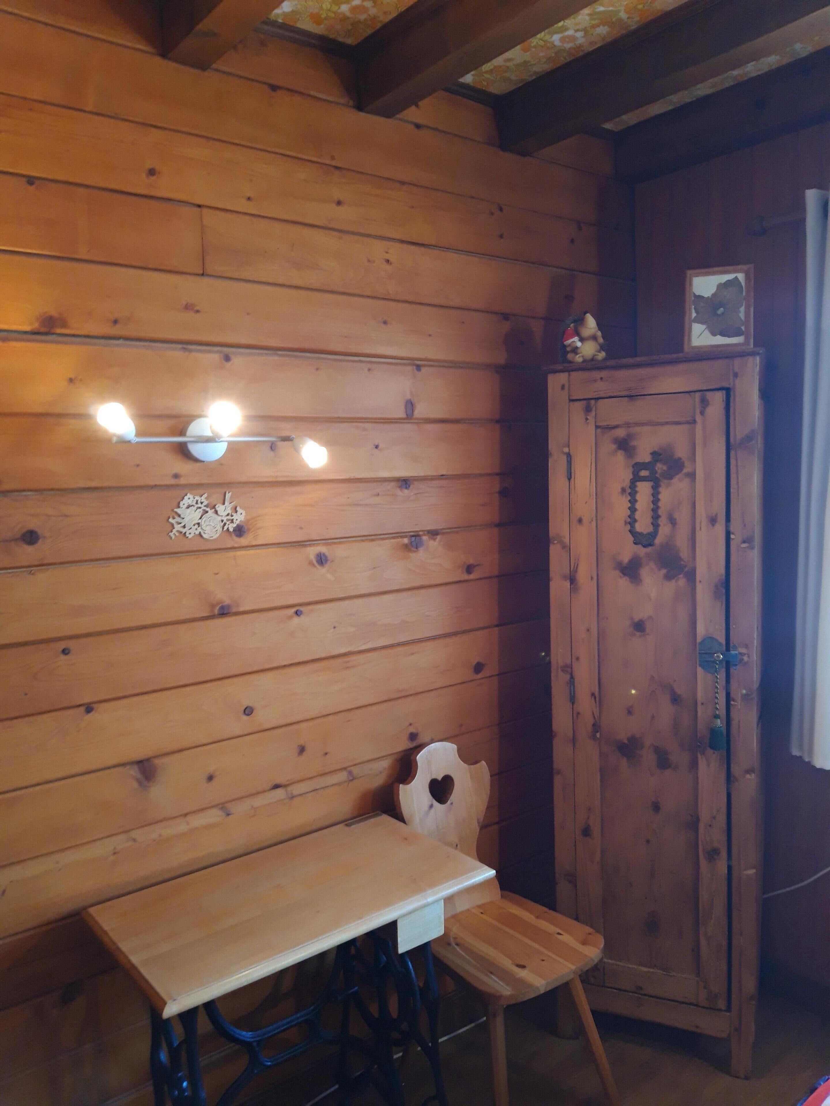 A wooden interior with a table and a cabinet.