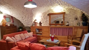 A cozy room with a red sofa, a wooden cabinet, and a mirror. - Serre Chevalier Apartment in a house Country, nice amenities. (Saint-Chaffrey)