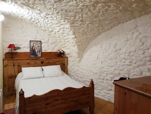A bedroom with a wooden bed, a red lamp, and a poster on the wall. - Serre Chevalier Apartment in a house Country, nice amenities. (Saint-Chaffrey)