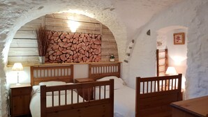 A cozy room with a wooden bed, a small table, and a lamp. - Serre Chevalier Apartment in a house Country, nice amenities. (Saint-Chaffrey)