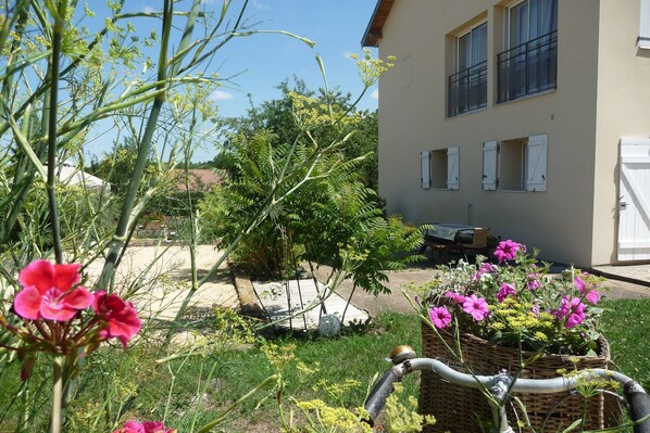 A garden with flowers and a house in the background. - GITE-APART comfortable between Nancy and Metz in "Little Switzerland Lorraine". (Villers-En-Haye)