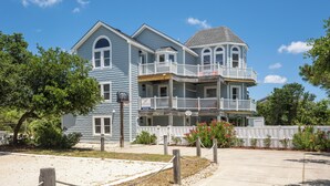 A large, two-story house with a balcony and a porch. - Crazy4Shore: Dog-friendly, Large Private Pool, Hot Tub, 1500 Ft to Beach Access (Corolla)