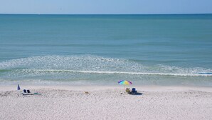 Una playa con algunas sillas y un paraguas de colores.
