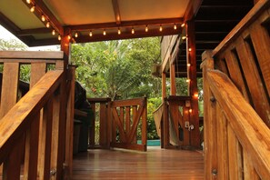 A wooden staircase leading to a covered area with string lights.
