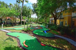 Play a round of golf amidst lush greenery and winding paths.