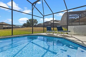 Una piscina con vistas despejadas al cielo y casas circundantes.