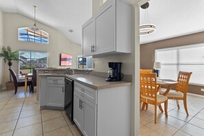 Enjoy meals in the kitchen with a central island and dishwasher, and dine at the wooden table with a large window.