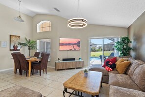 Relax in this stylish living area with a flat-screen TV, comfortable seating, and a dining table for meals.