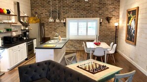 A compact kitchen with a dining area, a ceiling fan, and a large window. - STONES THROW RETREAT in Downtown Lewisburg (Lewisburg)