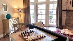 A cozy living room with a chessboard, a sofa, and a fireplace. - STONES THROW RETREAT in Downtown Lewisburg (Lewisburg)
