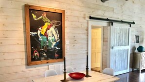 A dining area with a wooden table, white chairs, a red bowl, and a framed painting on the wall. - STONES THROW RETREAT in Downtown Lewisburg (Lewisburg)
