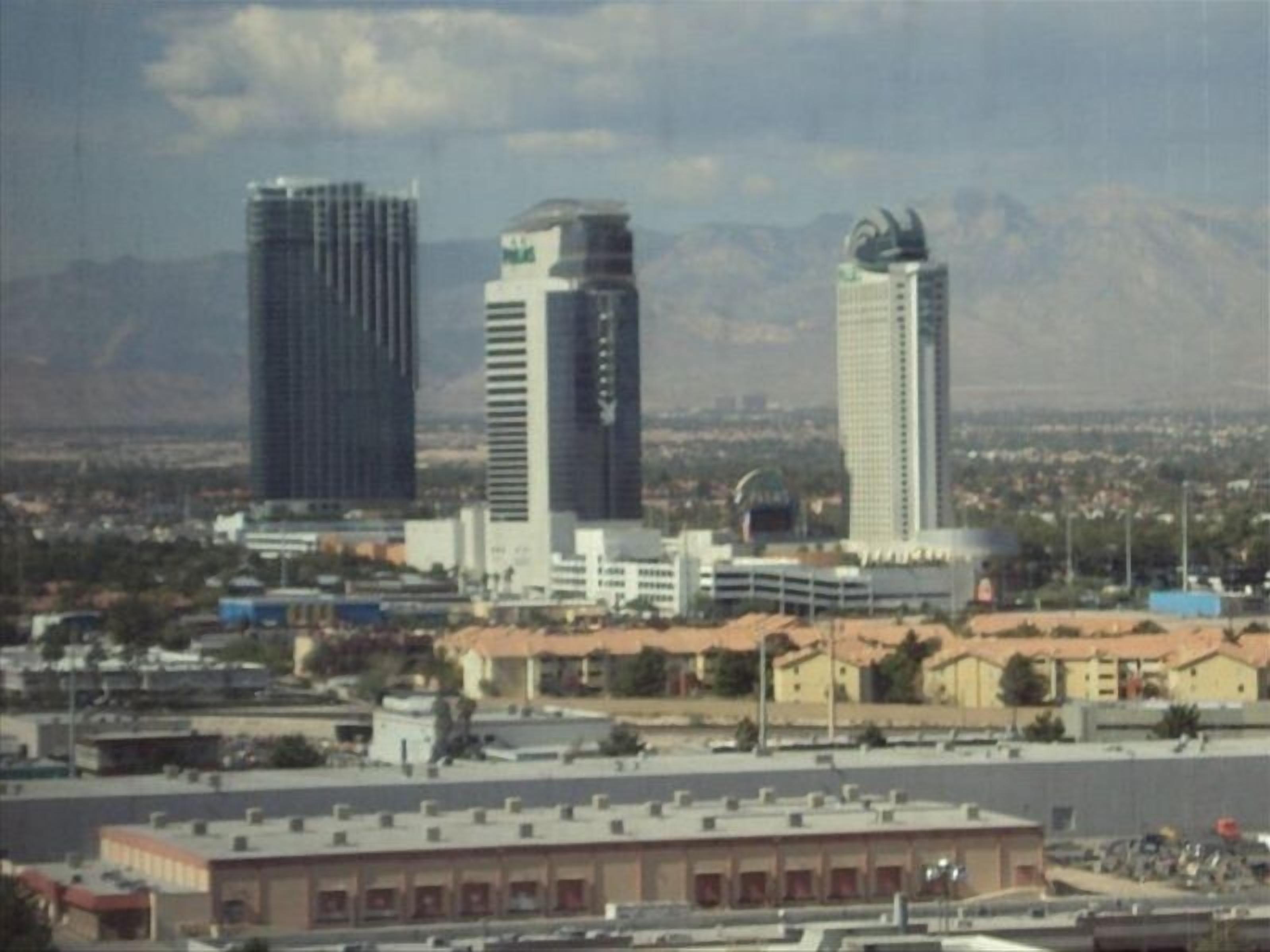 A cityscape with several high-rise buildings, including a distinctive building with a curved top.