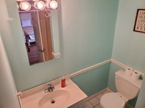 A bathroom with a sink, mirror, and toilet.