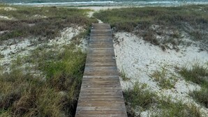 A wooden boardwalk leading to a beach with a clear sky and ocean in the background. - Relax With Walls Of Windows Directly On The Gulf! (Gulf Shores)