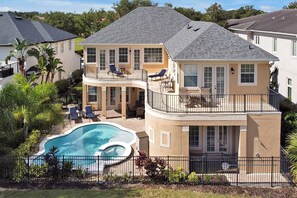 A two-story house with a swimming pool, a covered patio, and a fenced backyard. - 🏝️Quiet Private Setting-Theatre & Game Room, large Pool (Kissimmee)