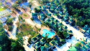 An aerial view of a residential area with houses, a swimming pool, and a road. - HangLoose14AD-Beautiful Beach Cottage@ the Purple Parrot Resort/Perdido Key FL (Pensacola)