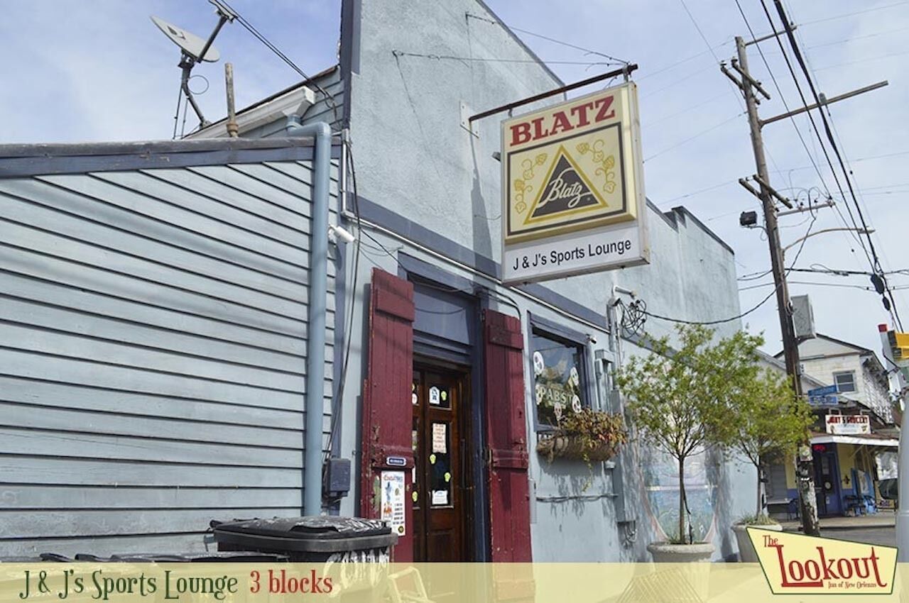 A building with a sign reading "BLATZ" and "J & J's Sports Lounge" on the facade.