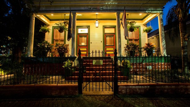Un hotel con un porche, columnas y un letrero que dice "The Lookout Inn".