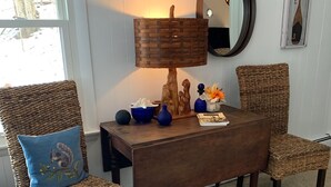 Une pièce chaleureuse avec des fauteuils en osier, une table basse en bois et une lampe.