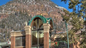 Un edificio a più piani con facciata in mattoni, ampie finestre e balconi decorati a festa.