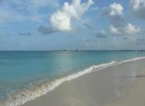 A beach with clear turquoise water and a sandy shore.