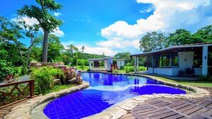 A swimming pool with a blue tiled bottom, surrounded by a wooden deck and lush greenery. - Miraflores Boutique Hotel (San Andrés)