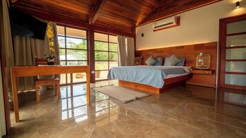 Ein Schlafzimmer mit einem Bett, Holzboden und einem Fenster.