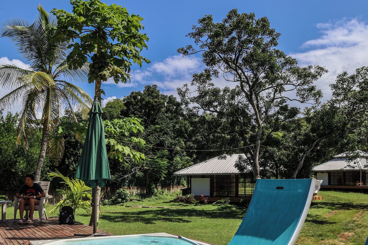 Terraza de madera con dos sillas reclinables turquesa y una pequeña piscina.