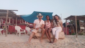 Une plage de sable avec une structure en bois et un auvent bleu.