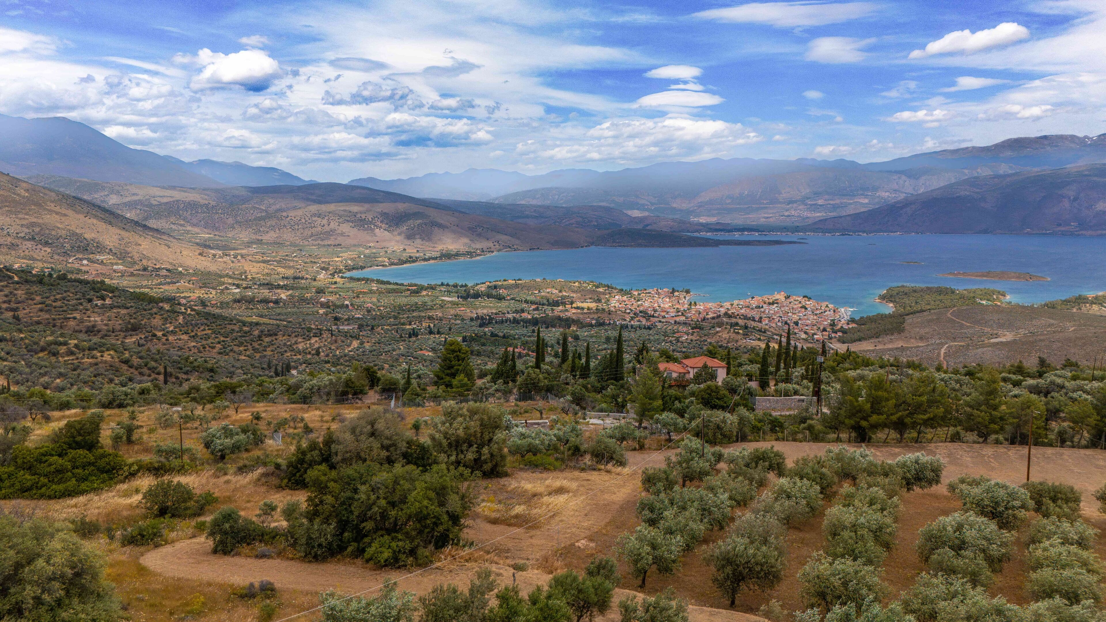 A coastal town with a view of the sea and mountains in the background.