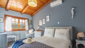 A bedroom with a bed, a desk, a chair, and a window with curtains. - Maistros Studios (Delphi)