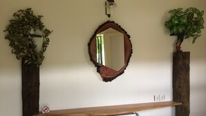 A mirror with a wooden frame, flanked by two potted plants. - Farmotel Stefania (Szakadat)