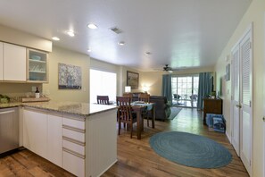 A kitchen with white cabinets, a granite countertop, and a dining area with wooden chairs and a table. - July 6-10; 18-23 available!! Great rates! Clean, Cozy! Primary spa shower! (Branson)