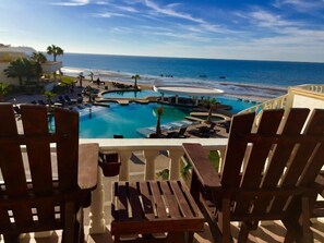 Relax by the ocean with a swim in the multi-tiered pool surrounded by lounge chairs and palm trees.