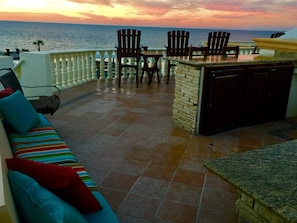 Enjoy ocean views from this outdoor seating area with a sofa, chairs, and bar counter.