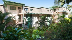 A two-story house with a pool, surrounded by tropical plants and palm trees. - Sunset Hale Kona: Ocean, Golf Course View, Keauhou Bay, Kona, Sleeps 4 (Kailua-Kona)
