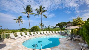 A swimming pool with lounge chairs and palm trees. - Sunset Hale Kona: Ocean, Golf Course View, Keauhou Bay, Kona, Sleeps 4 (Kailua-Kona)