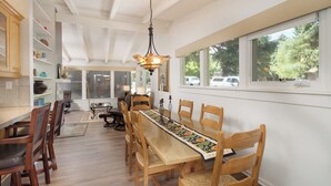 En matplats med ett långt träbord, flera stolar och en hängande lampa.