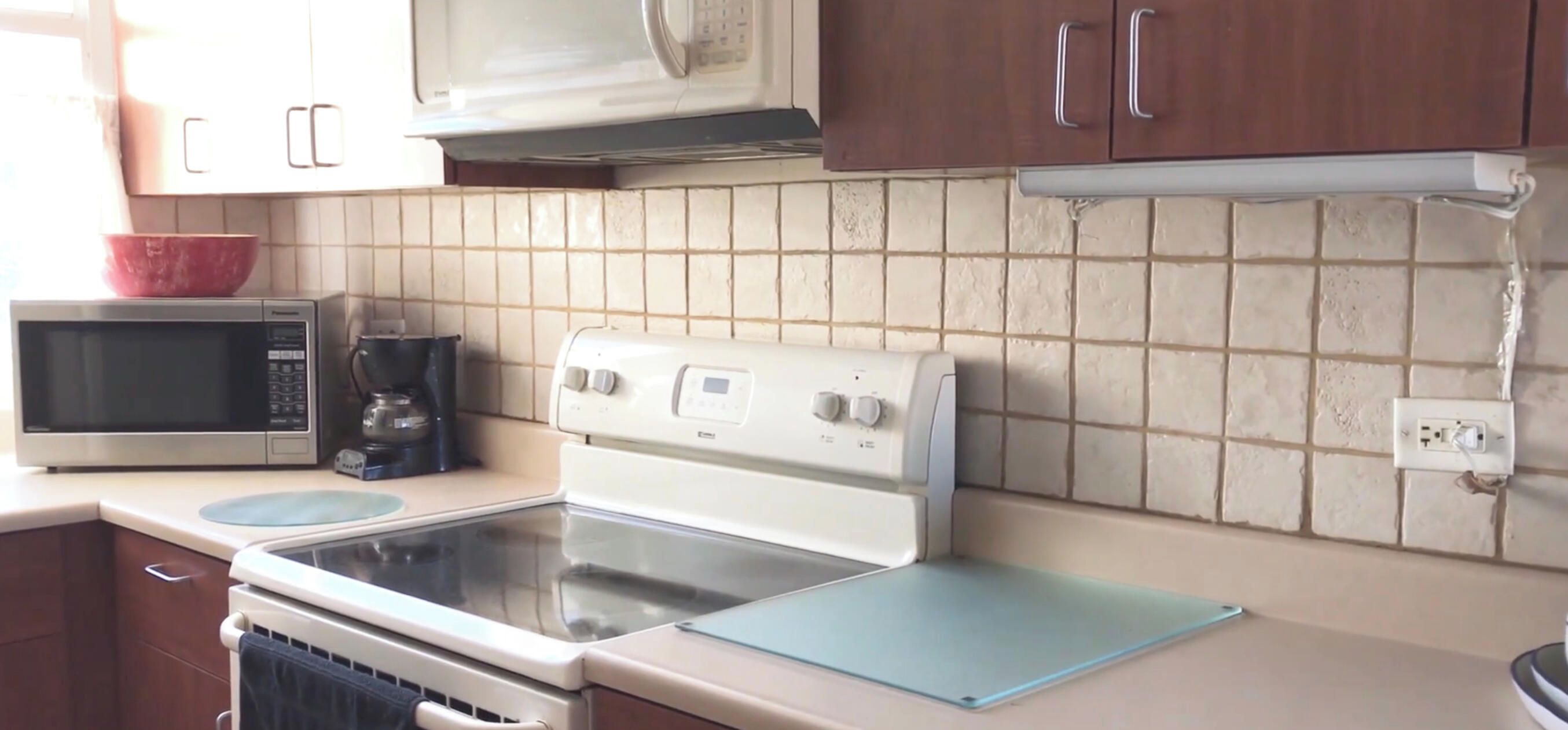 A kitchen with a microwave, coffee maker, and stove.