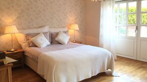 A bedroom with a bed, two bedside lamps, a nightstand, and a window with a view of greenery. - Charming House with a Fantastic View of Norway's Nature (Ørsta)