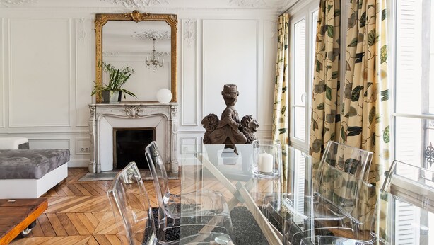 A room with a fireplace, a chandelier, a large mirror, and a table with chairs. - CAVALIER DES LIONS 2bedr 2 1/2baths (Paris)