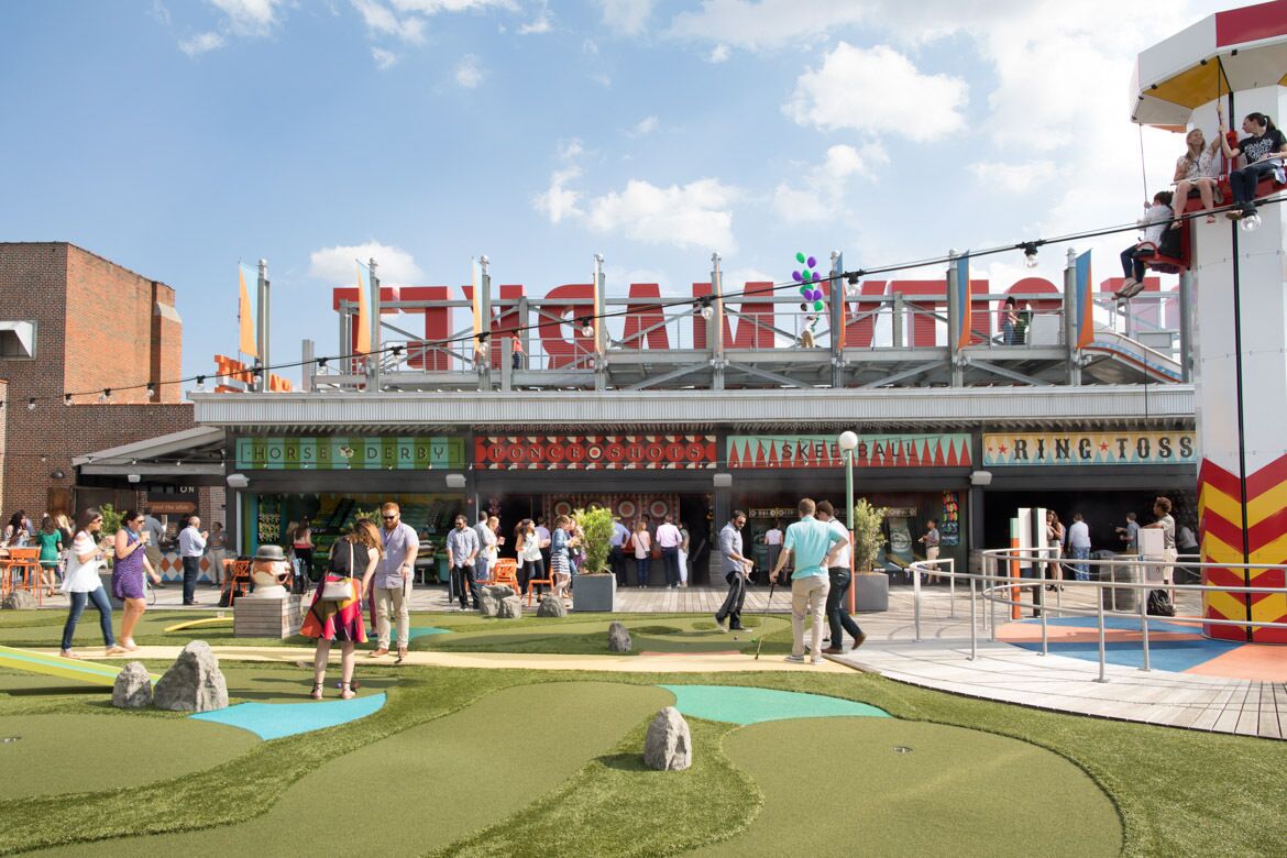 A building with a sign that reads "Horse & Derby" and "Ring Toss" indicating an amusement area.