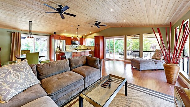 A spacious living area with a wooden ceiling, a sofa set, a coffee table, and a large window providing a view of the outdoors. - Luxury 3BR Wailea Kihei Retreat. Walk to Beaches, Private Lanai, Newly Remodeled (Kihei)
