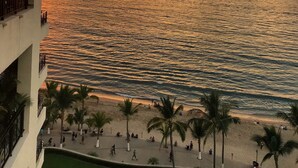 A beachfront hotel with a balcony overlooking the sea, palm trees, and a sunset view. - Panoramic Oceanview, Luxury Condo 3 bd, 3bath on the beach. (Puerto Vallarta)