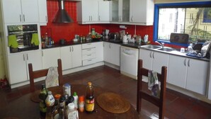 A kitchen with white cabinets, a red backsplash, and various kitchen appliances. - Spacious in-suite room Bo. Herrera, Asuncion (Asunción)