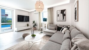 Una sala de estar moderna con un sofá gris, una mesa de centro blanca y un ventanal con vistas a una piscina.